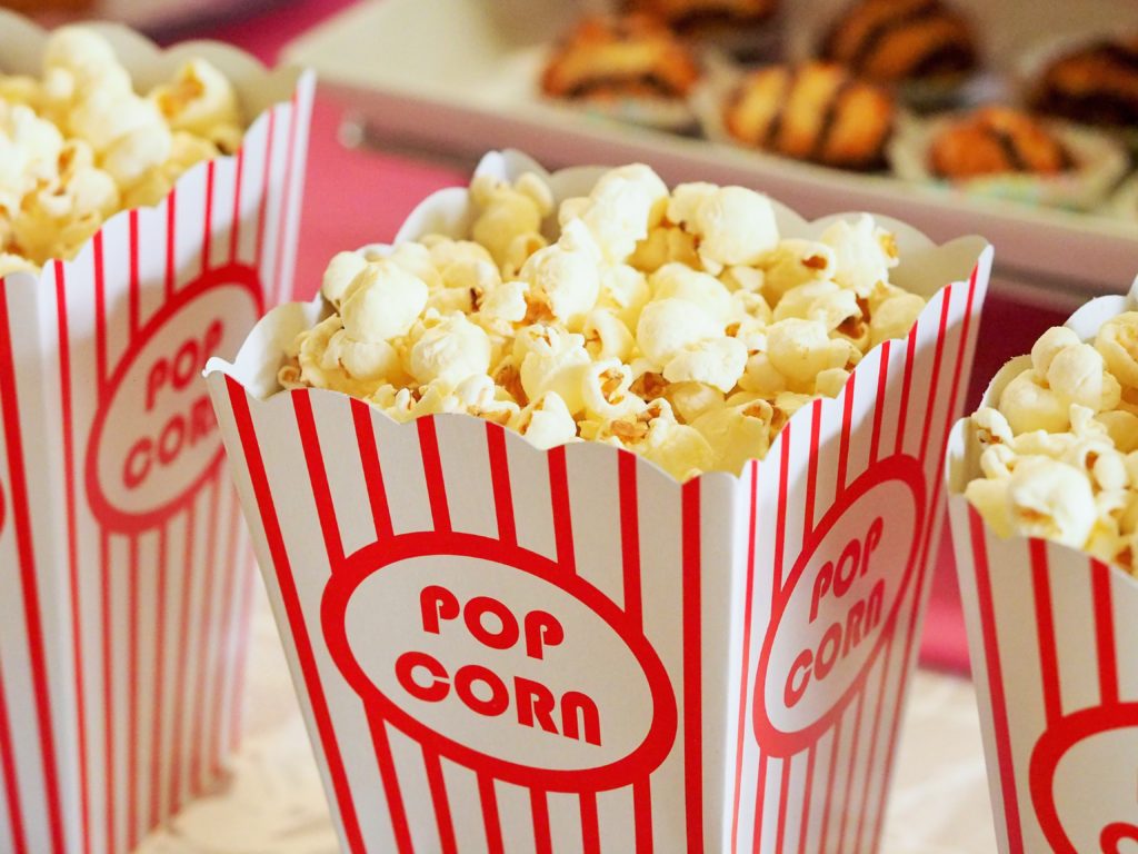 Photograph of fresh popcorn in a cheerful striped container